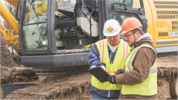 Machine control. Two men and digger background 